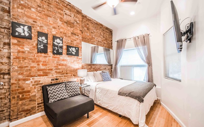 Room with brick wall, window and bed